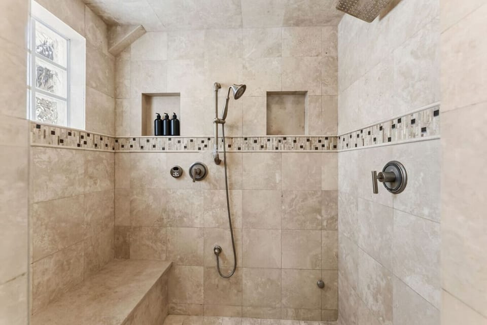 Primary bedroom with king bed, double sided fireplace, smart TV, and spa-like en suite bathroom