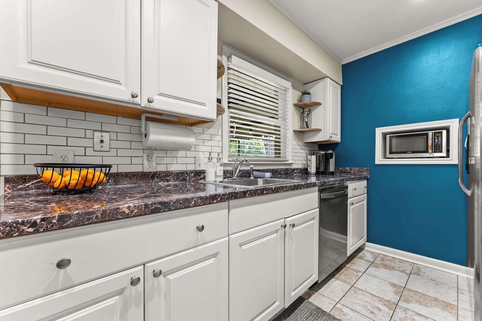 Granite counters, ample storage, and a pop of color make this kitchen as functional as it is fun to cook in.