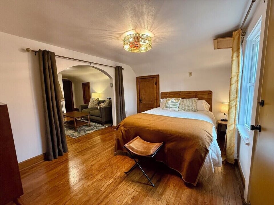 Bedroom with plush Queen size bed, multi-plug charging bedside lamp.