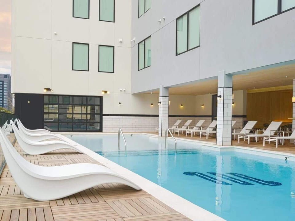 Communal Area: Sparkling blue pool located on the third-story with city views.