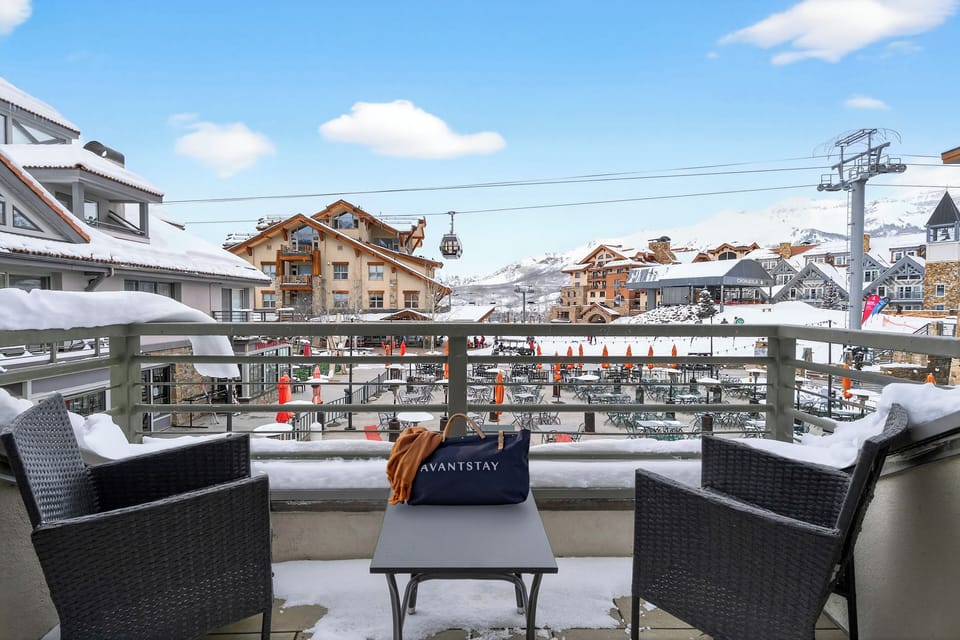 Scenic balcony view of the snowy mountain village and ski lifts.