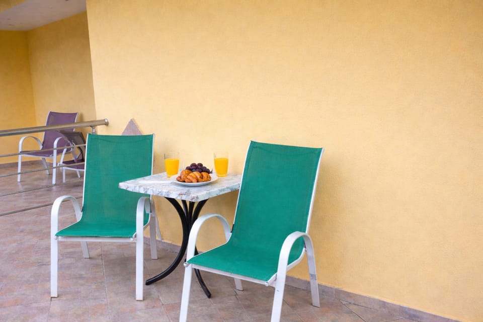 Outdoor balcony table for light meals or coffee, offering a peaceful setting in a quiet central neighborhood.
