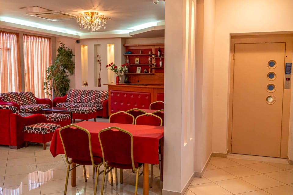 Spacious lobby with tables for breakfast and indoor seating, plus easy access to the elevator for the upper floors.
