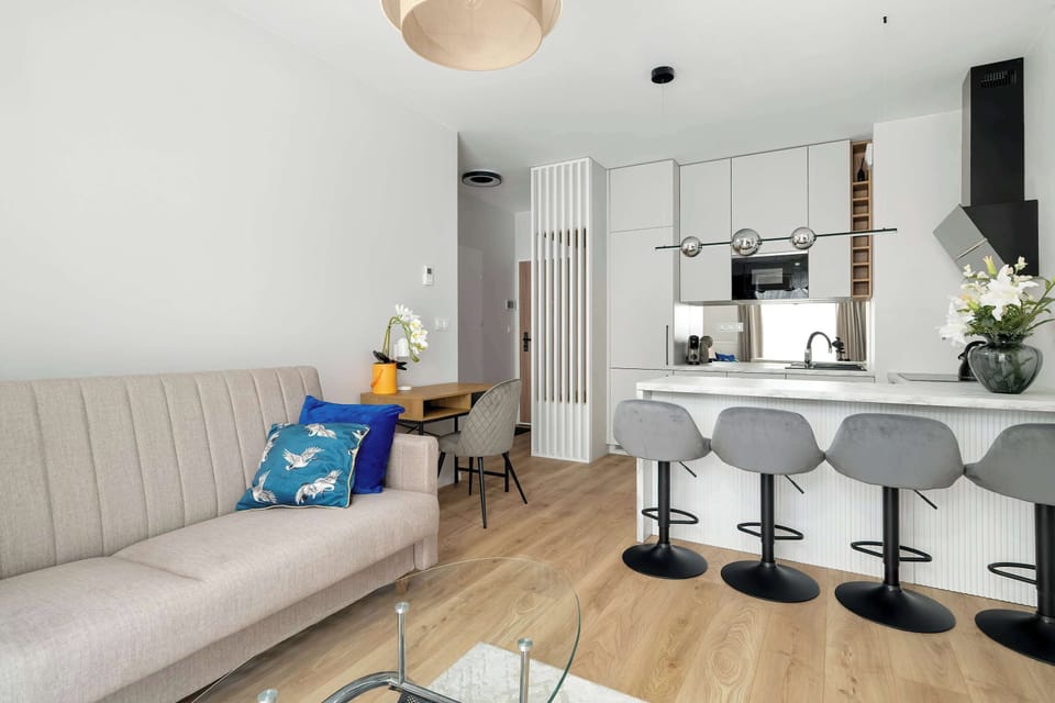 Living room with sofa and kitchen island, combining comfort and functionality.
