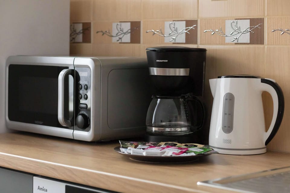 Kitchen Counter with Appliances – Close-up of kitchen counter with coffee machine, kettle, and microwave.