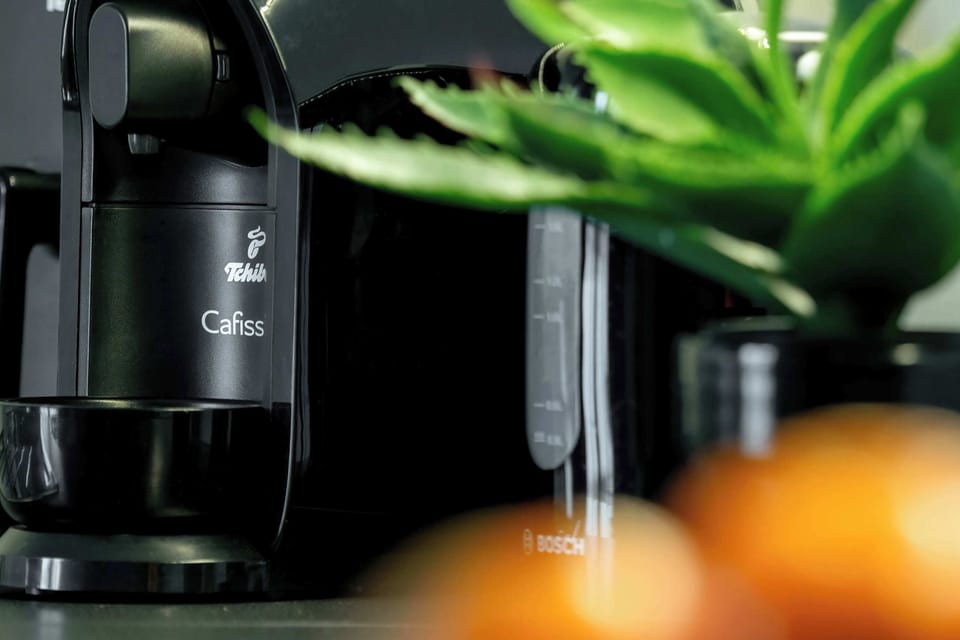 Close-up of coffee machine and greenery detail, enhancing the modern interior style.