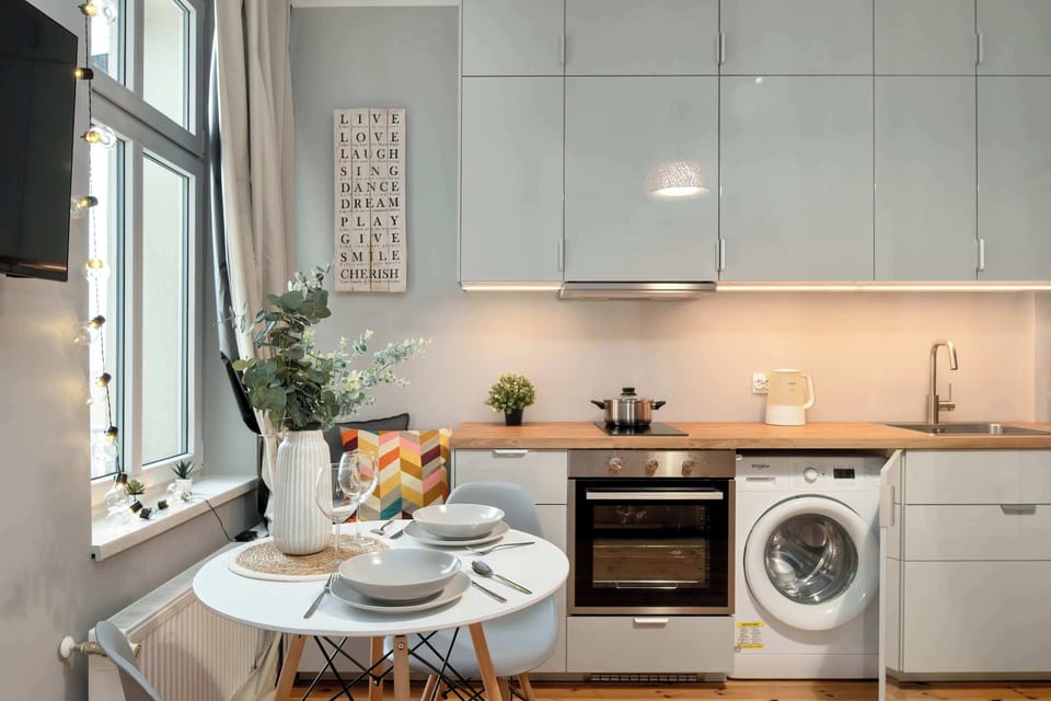 Kitchen with washing machine and dining table.