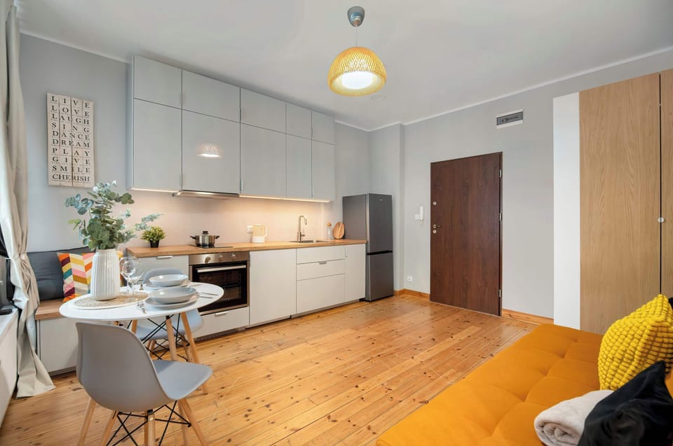Living room with kitchen and entrance door.