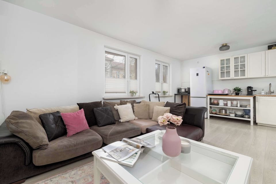 A living room angle showing a sofa with cushions and a white coffee table. Light walls and minimal décor keep the space bright. The design feels cohesive and clean.