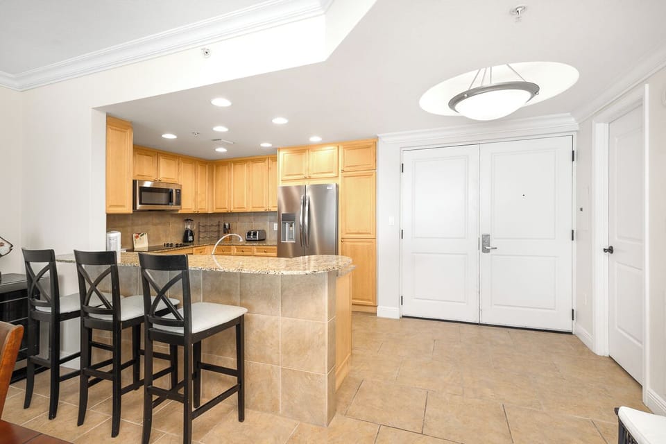 Your fully equipped kitchen awaits with granite counters, stainless appliances, and breakfast bar seating for casual meals and morning coffee.