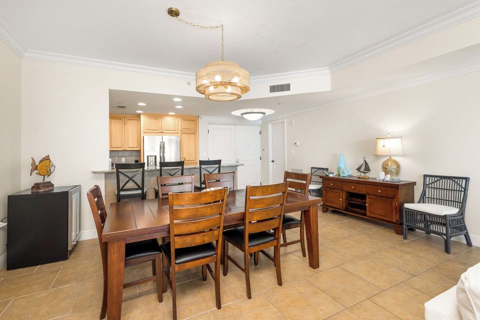 Gather around this elegant dining table where warm wood tones and sophisticated lighting create the perfect atmosphere for memorable meals together.