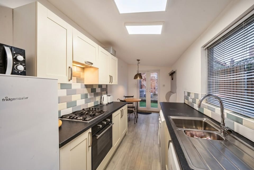 Bright galley kitchen with skylights and double doors opening to the courtyard.