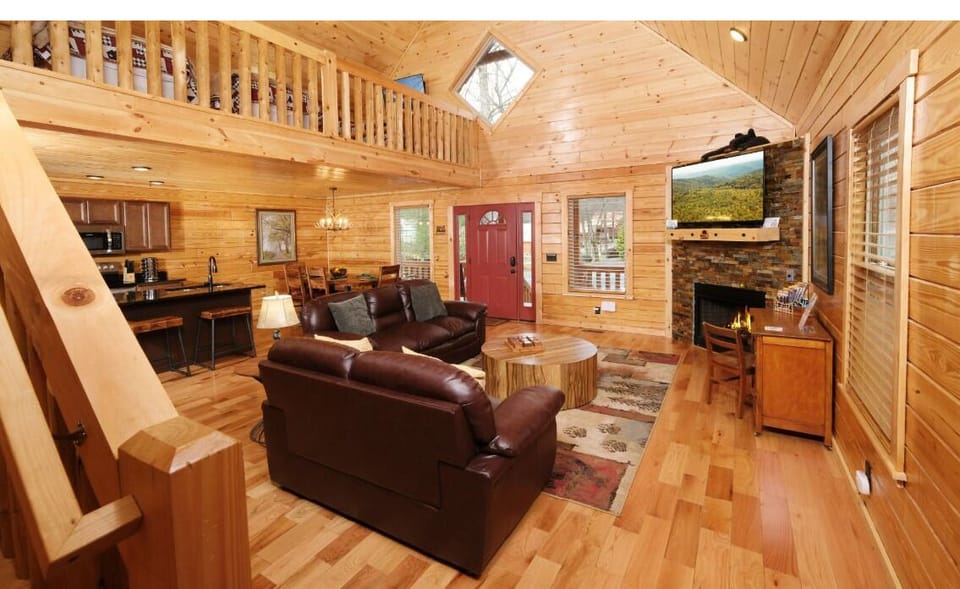 Cozy up in this warm cabin living room with rich leather seating and crackling fireplace for perfect mountain evenings.