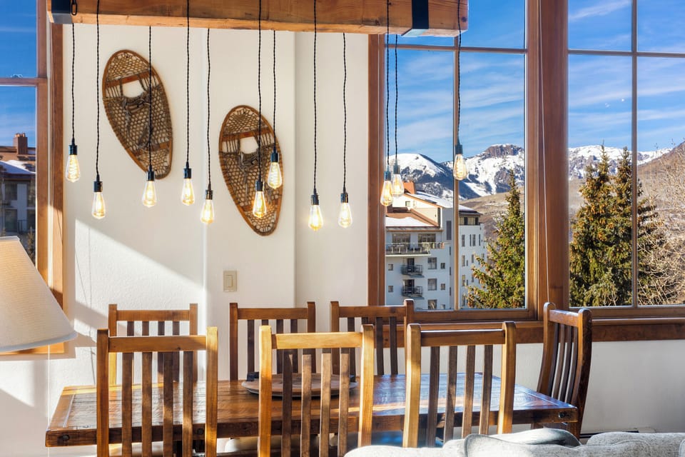 Gather around your mountain-view dining table, where rustic wood meets alpine elegance and stunning snowy peaks create the perfect backdrop for memorable meals.