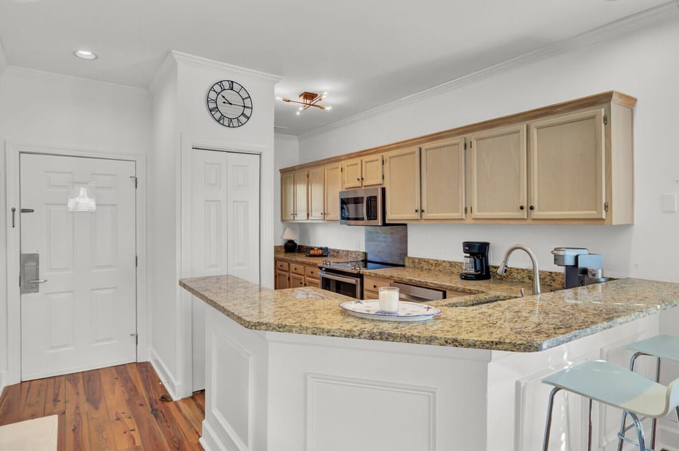 Your fully equipped kitchen features granite countertops, modern appliances, and a breakfast bar where you can start each morning with coffee.