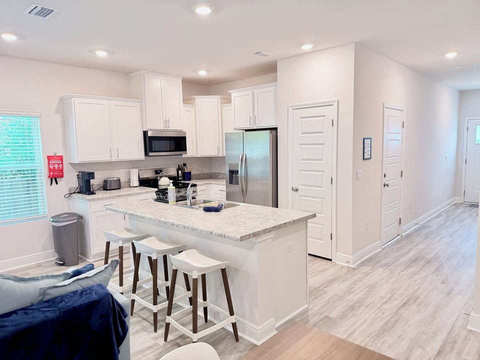 Bright modern kitchen with island seating and stainless steel appliances