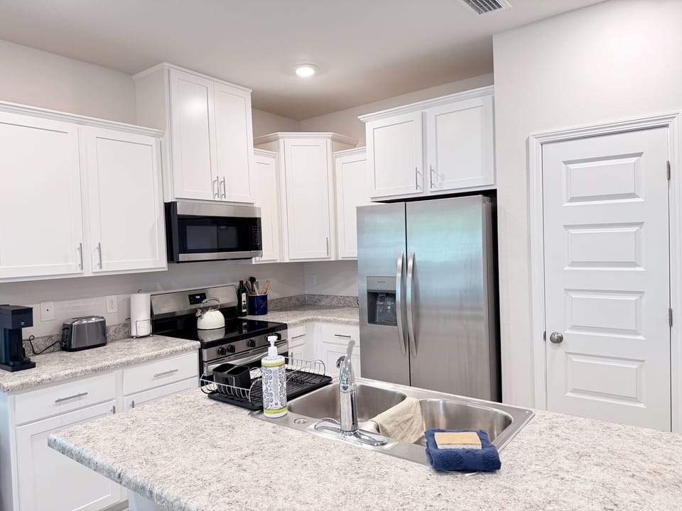 Bright modern kitchen with island, double sink, and stainless appliances