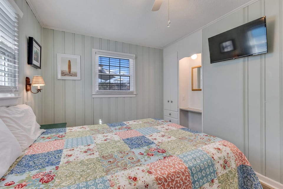 Drift off in your cozy bedroom with charming coastal details, soft quilted bedding, and warm lighting creating the perfect seaside retreat.