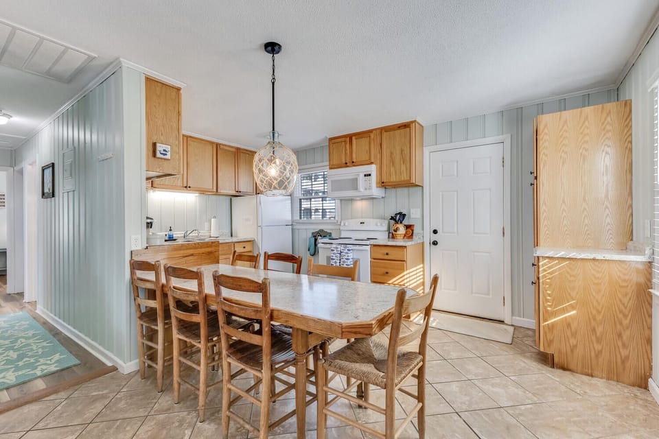 Your open kitchen and dining space features warm wood cabinetry, modern appliances, and a cozy dining table where memorable meals begin.