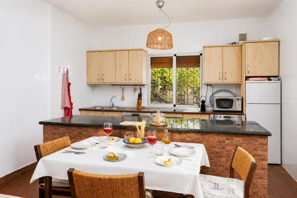 Open-plan living room with sofas, dining area, kitchen, ornamental fireplace, A/C, WiFi internet, and satellite TV