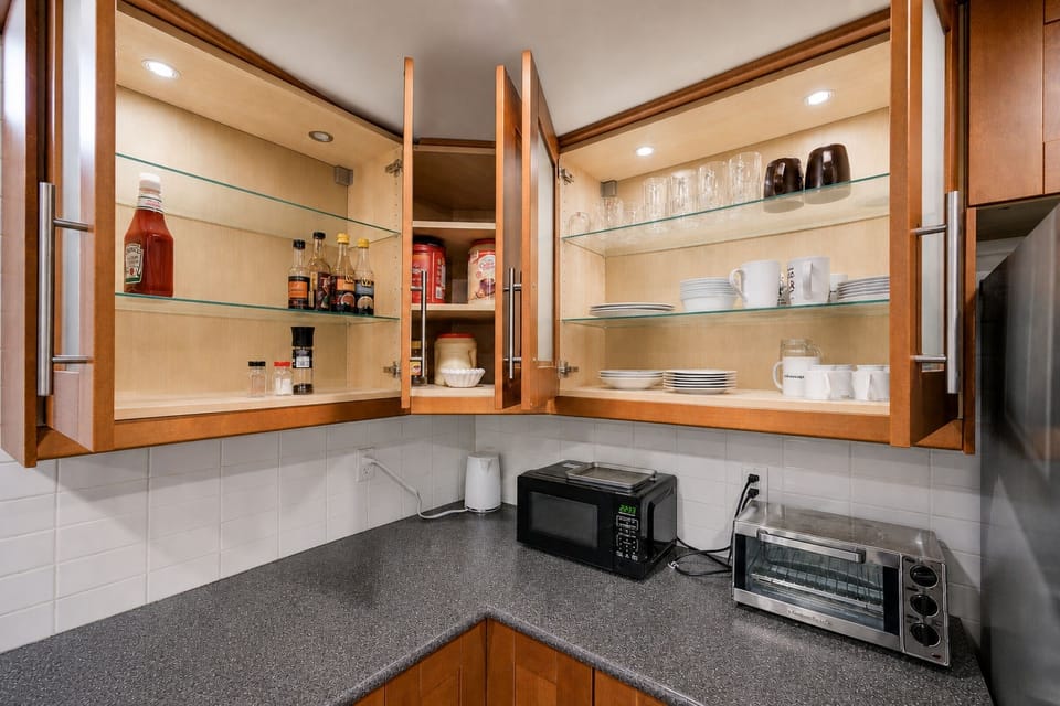 Bright kitchen with stocked cabinets, glassware, and handy appliances
