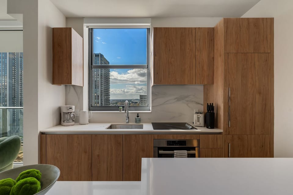 Fully equipped kitchen with warm wood cabinetry and sleek finishes.