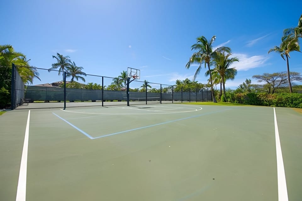 Play a friendly match on sunlit courts surrounded by palms.