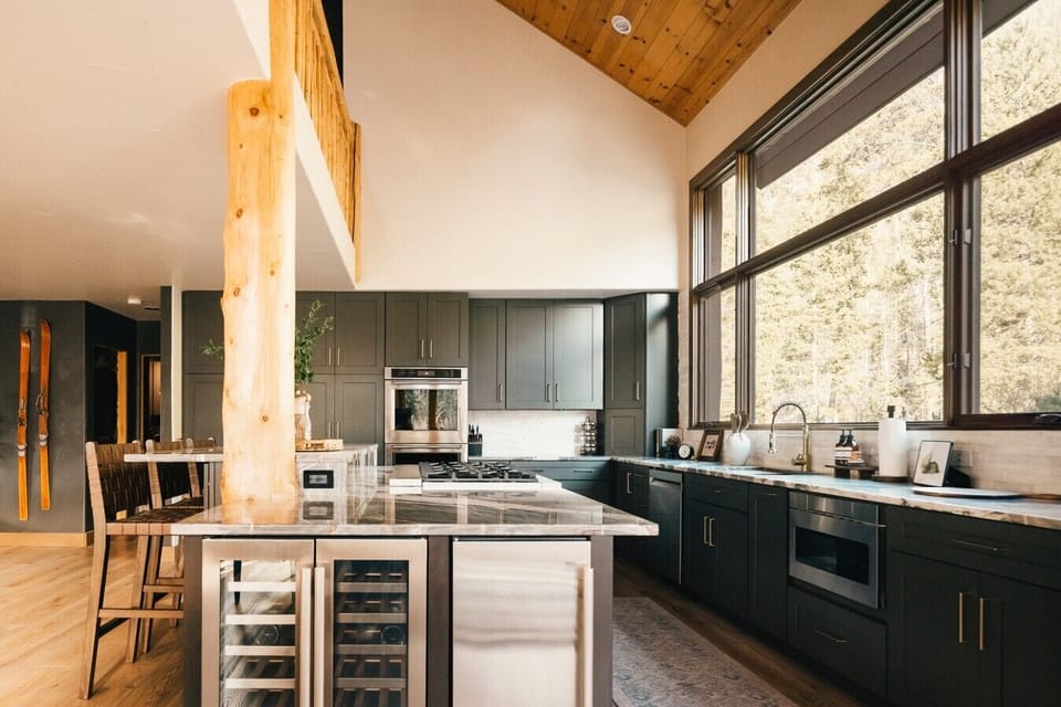 The kitchen was built for feeding a crowd, with double ovens, a 7-burner + griddle cooktop, wine fridge, ice maker, and seating that keeps everyone close to the action.