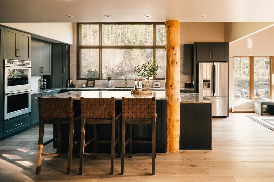 The kitchen’s oversized picture window brings in natural light and forest views