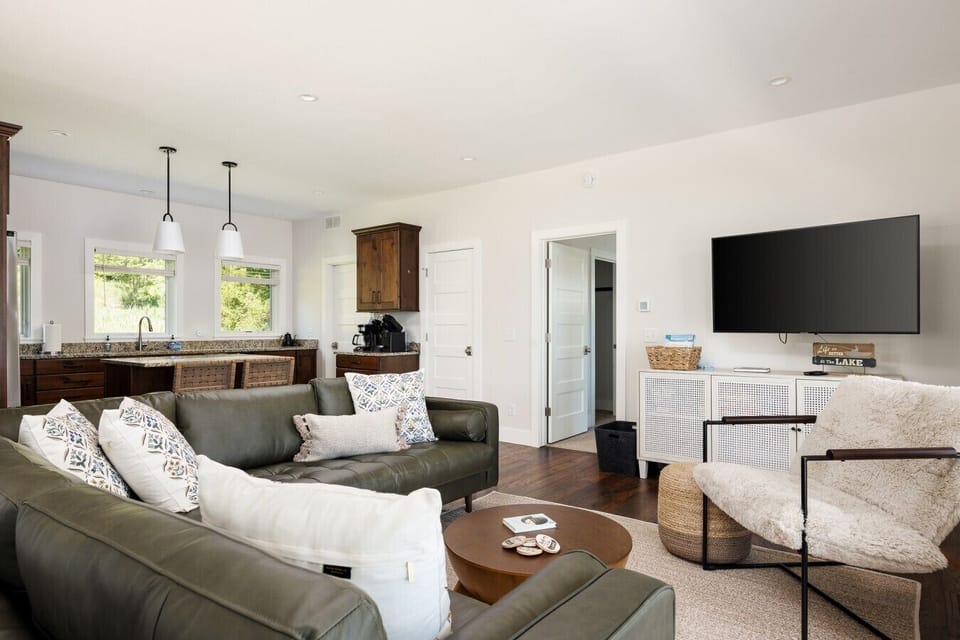 Living room facing kitchen, bathroom door, and master bedroom wide shot