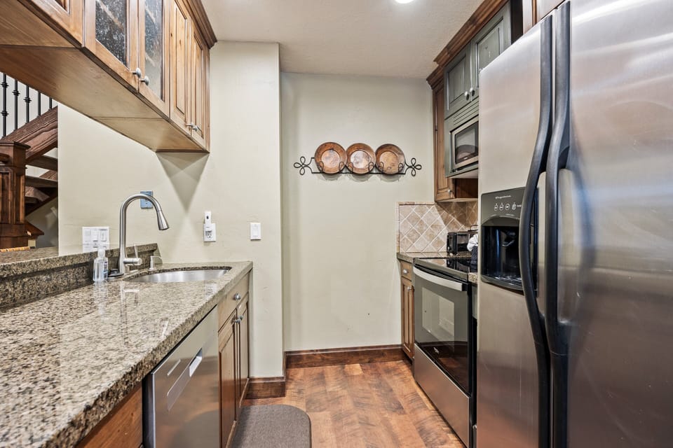 Compact yet functional kitchen featuring granite countertops, stainless steel appliances, and everything needed to prepare meals during your stay.