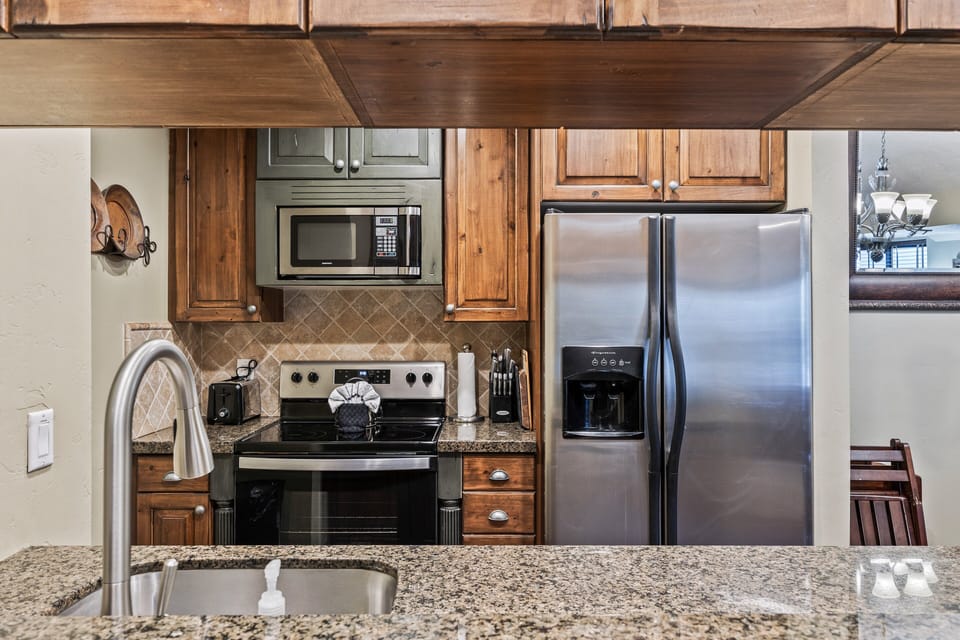 Well-appointed kitchen with stainless steel appliances, ample cabinetry, and granite countertops—ideal for preparing meals and gathering with family or friends.