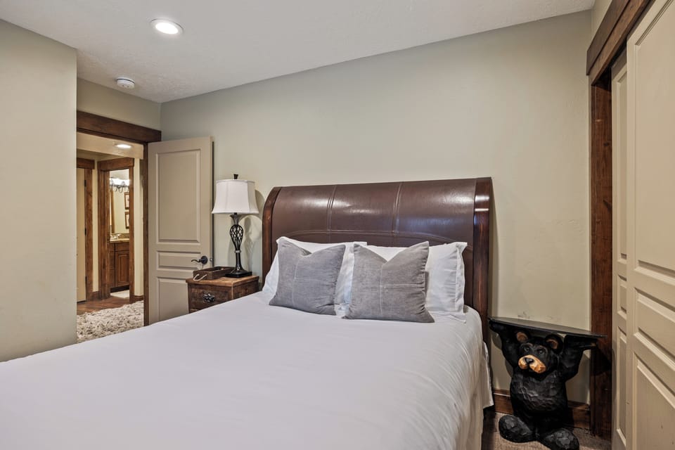 Comfortable queen bedroom featuring cozy bedding, bedside lighting, and convenient proximity to a full bathroom—perfect for guests seeking easy access and a relaxing retreat after a day of mountain adventures.