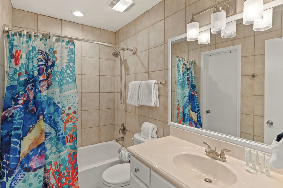 Full guest bathroom featuring a clean tub-shower combo and modern vanity.