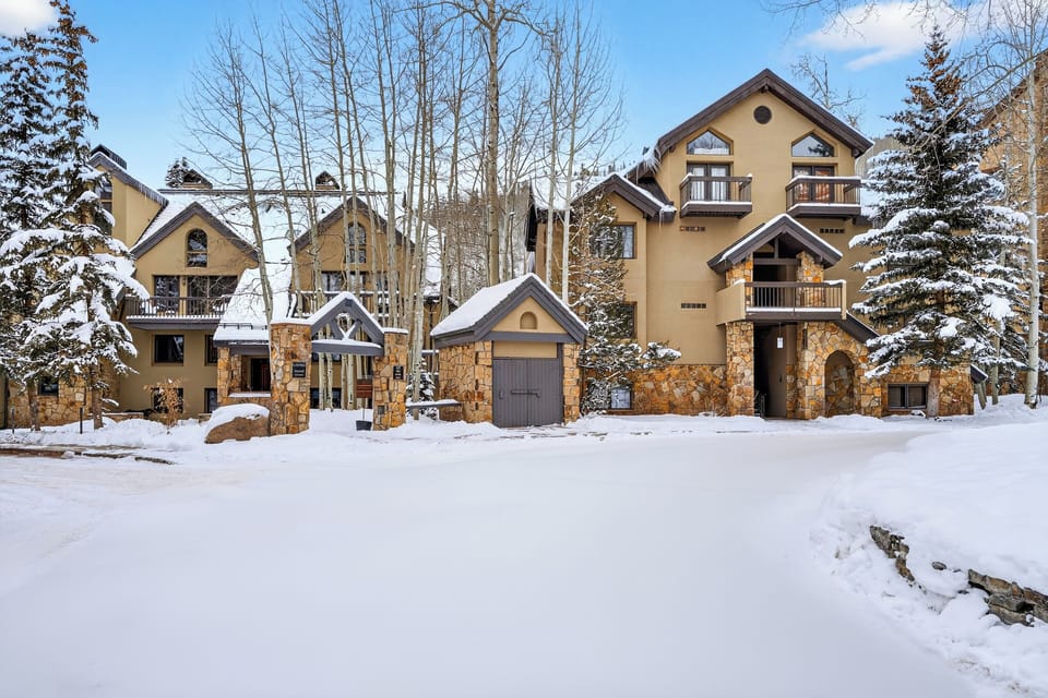 Charming mountain condo exterior set against a snowy alpine backdrop—your cozy Telluride home base.