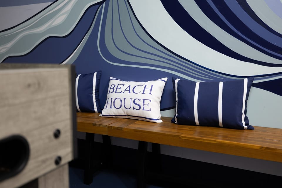 Where beach vibes meet friendly competition 🌊
Kick back on the built-in bench beneath our custom Jacksonville Beach mural — the ultimate hangout space for all ages.