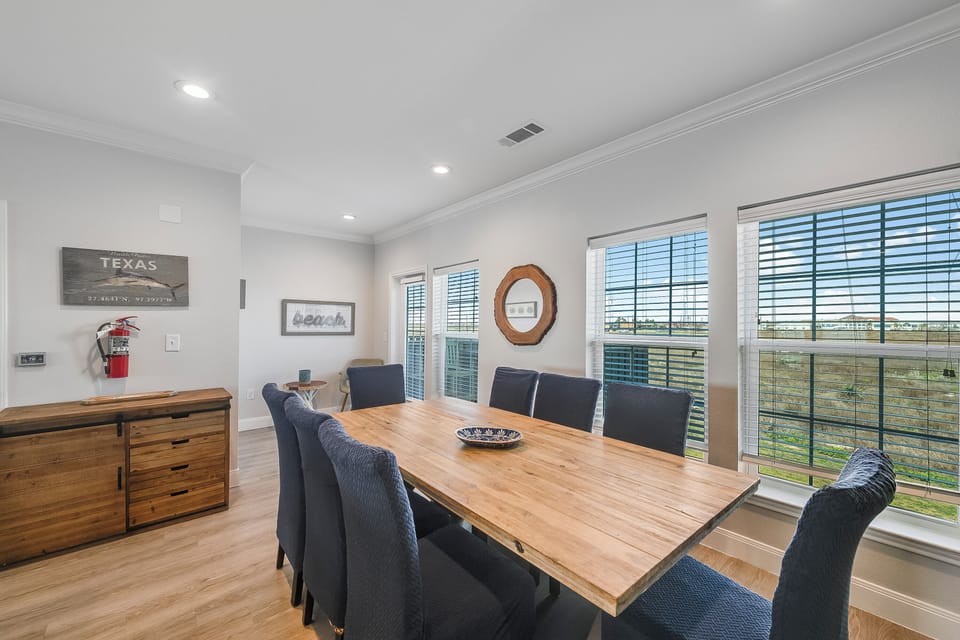 Gather around this beautiful wooden dining table where meals become memories, surrounded by comfortable seating and natural light.