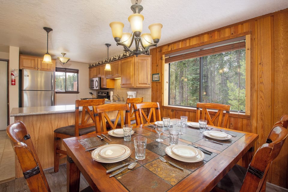 Gather around this beautiful wooden dining table where warm meals and lasting memories await, surrounded by forest views.