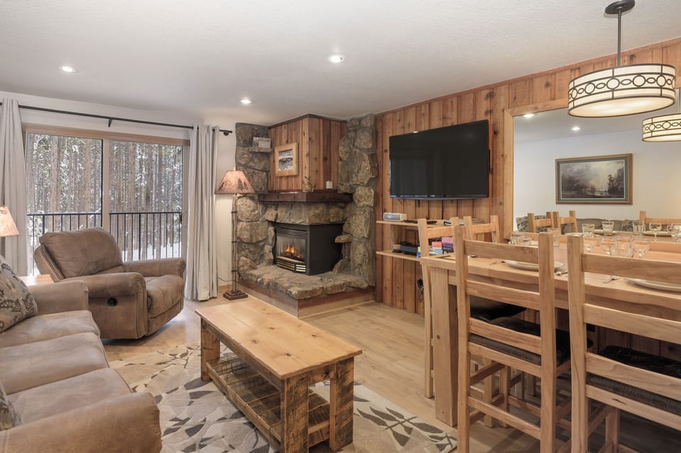Cozy up by your stone fireplace while snow-covered birches create a peaceful winter backdrop through your windows.
