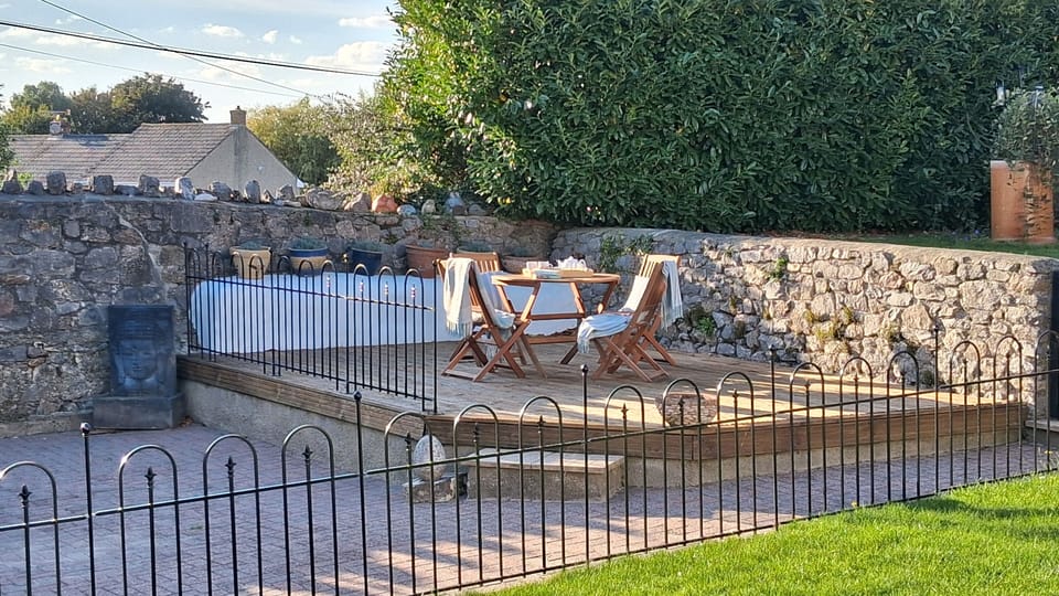 Enclosed outside space of patio and decking with outside furniture.
