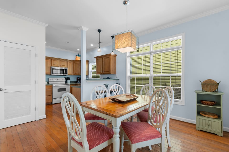 Gather around this inviting dining table where your meals become memories, bathed in natural light from expansive windows.