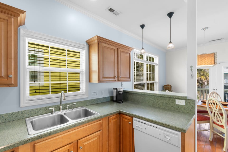 Your fully equipped kitchen features warm wood cabinetry, and bright natural light streaming through large windows for effortless meal prep.