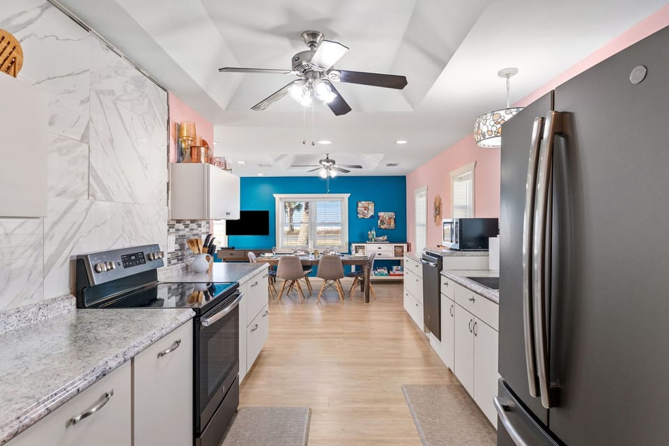 Cook together in your fully equipped kitchen, then gather around the dining table where vibrant turquoise walls create an inviting backdrop for meals and memories.