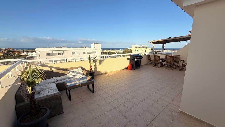 Large balcony with seating and dining area and bbq