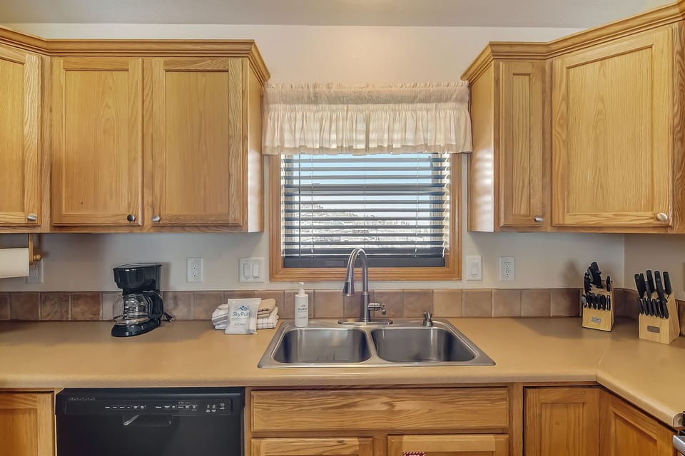Prepare your favorite meals in this fully equipped kitchen with warm wood cabinets, granite counters, and all essentials.