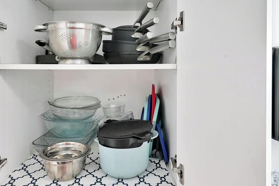 Your fully equipped kitchen cabinet holds everything needed for cooking adventures - from cast iron skillets to mixing bowls.