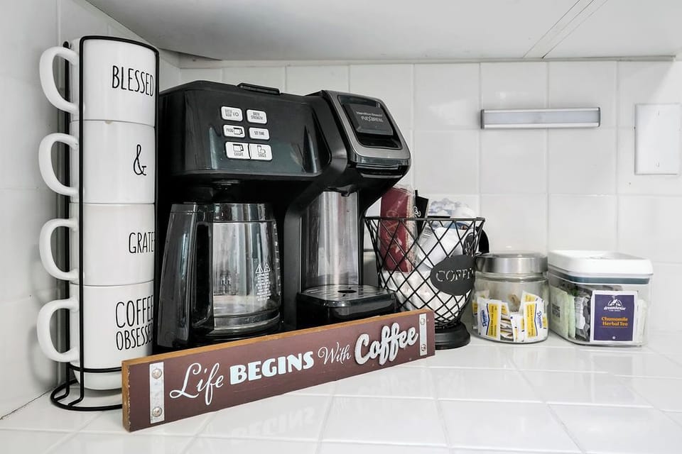 Start your mornings right with this thoughtfully stocked coffee station, complete with premium machine and artful mugs for your perfect cup.