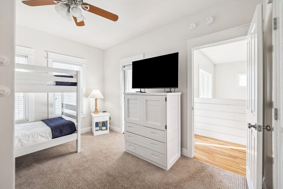 Your coastal bedroom features cozy bunk beds, smart TV entertainment, and thoughtful storage to make your beach getaway comfortable and organized.
