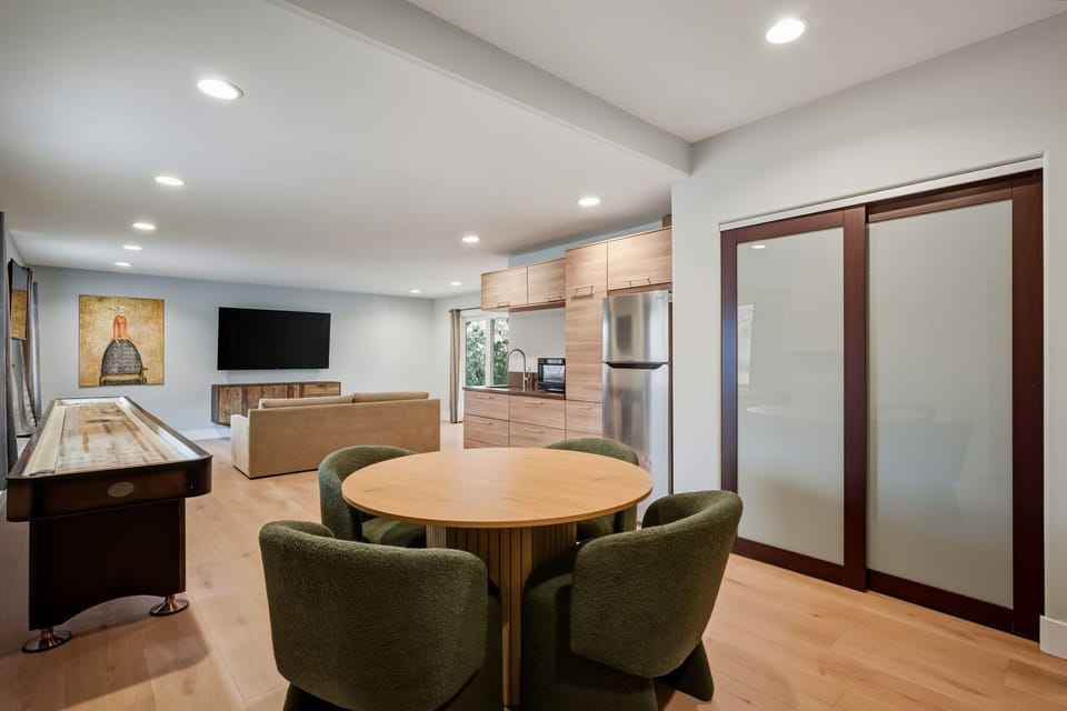 Game room with shuffleboard, board games, and TVs.