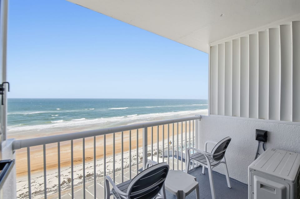 This inviting balcony features sleek chairs, ideal for sipping morning coffee while gazing at the rolling waves and feeling the coastal breeze on your skin.